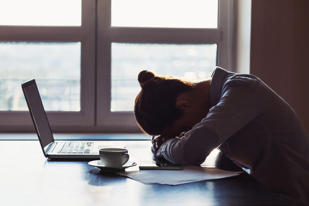 Tired businesswoman sleeping on table in office.